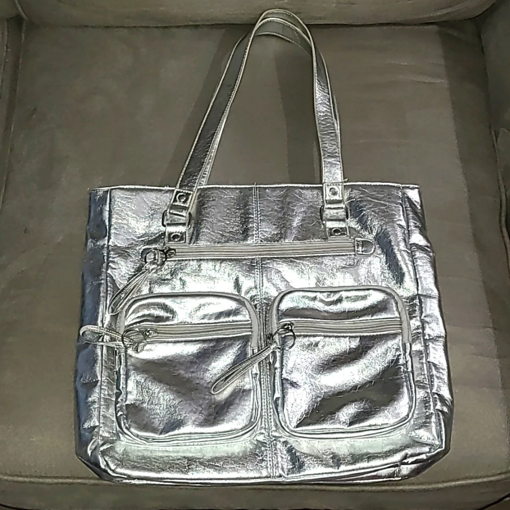 Shiny silver metallic handbag. Outside pockets snap closure clean inside